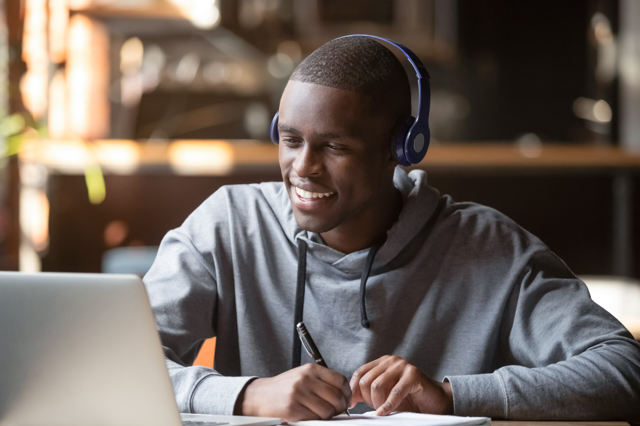 young adult with headphones remotely learning